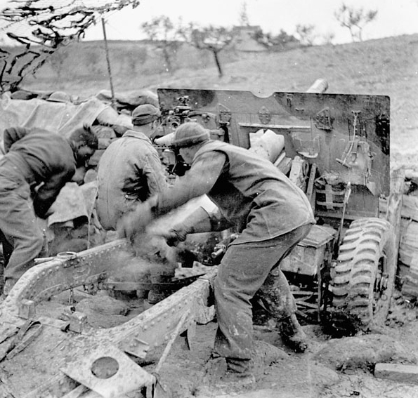 gunners firing 25 pounder gun under cold and muddy conditions